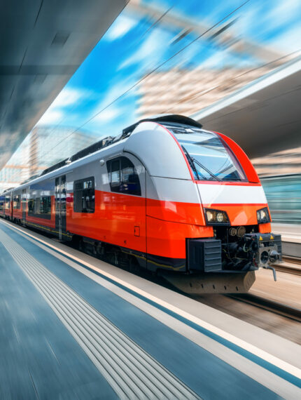 High speed train in motion on the train station at sunset High speed train in motion on the train station at sunset in Vienna, Austria. Red modern intercity passenger train with motion blur effect. Railway platform. Railroad. Commercial transportation